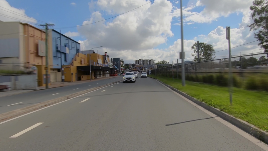 Rear facing driving point of view POV of suburban city streets, going over old bridge next to railway line - ideal for interior car scene green screen replace Royalty-Free Stock Footage #1069880320