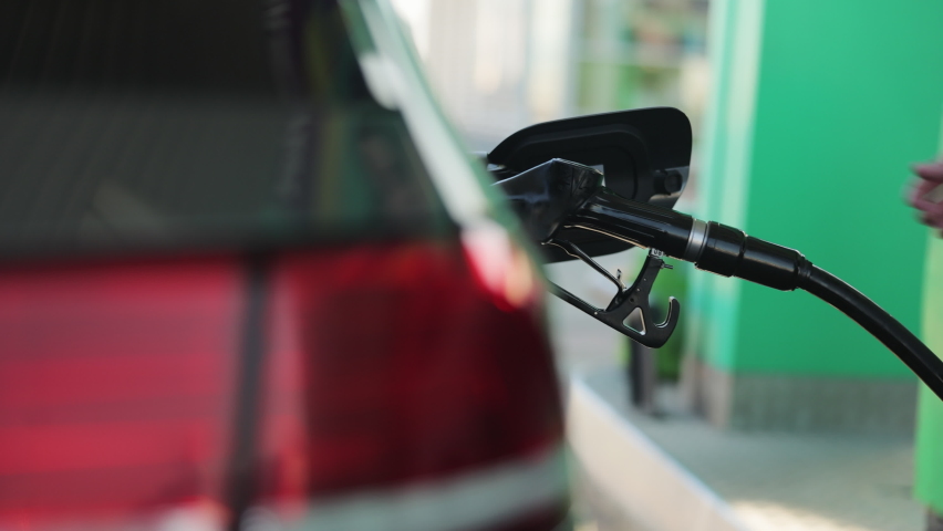 Unrecognizable businessman refueling car from gas station. Senior is refueling car at sunset. Caucasian businessman filling benzine gasoline fuel in car at gas station. Petrol prices concept | Shutterstock HD Video #1069885249