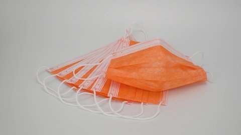disposable mask in orange on a white background. antiviral medical bandage for protection against  virus. Glamorous Surgical protective mask. 