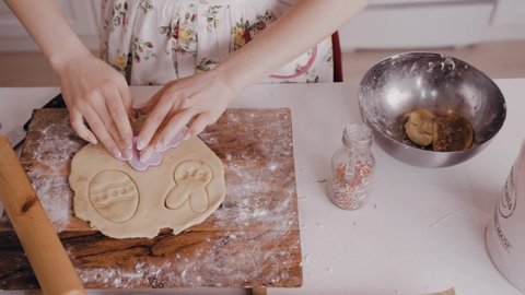 Woman making Easter cookies. Close up footage of woman making ginger cookies for Easter. Woman during preparing Easter cookies in the kitchen. Happy Easter day 2021