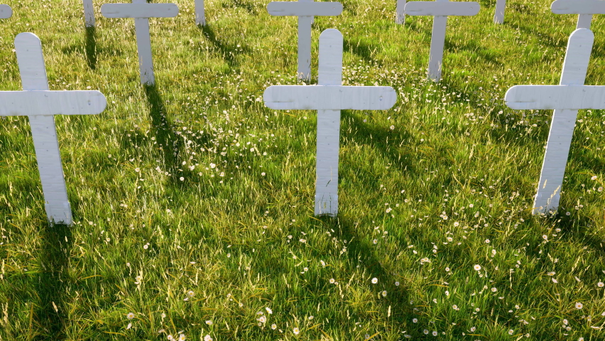 Camera panning slowly over a graveyard full of unmarked white crosses.