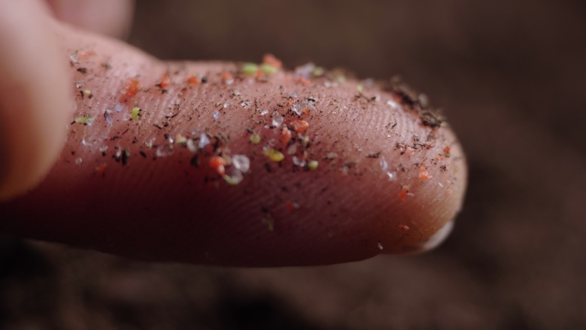 Pieces of microplastic on the finger. primary and secondary microplastics. small plastic pellets in human hands. soil contamination, marine plastic pollution, environment, ecology, earth | Shutterstock HD Video #1069922182