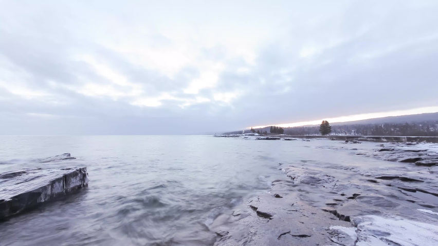 An Ultra Wide Angle Shot of an Icy Grand Marais Shoreline on the North Shore of Lake Superior during a Winter Sunset 4K Timelapse