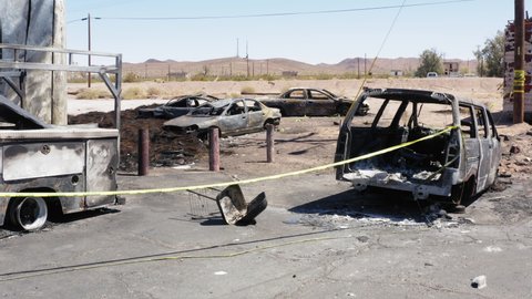 Destroyed cars scattered around aftermath of gas station explosion in desert