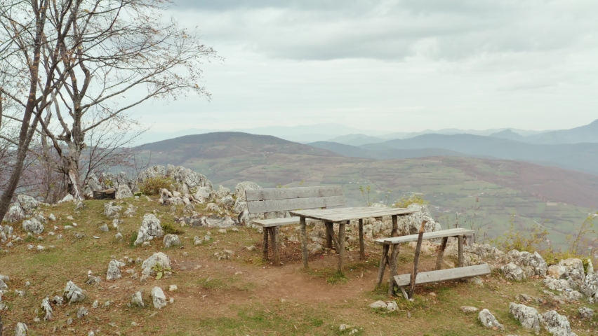 Old wooden bench overlooking mountain valley, scenic landscape aerial view