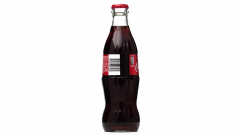 Estonia, Tallinn - March 2021: glass bottle coca-cola soda drink rotating on isolated white background.