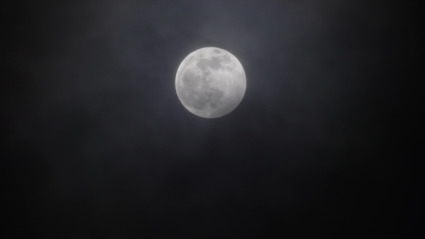 full moon moving between clouds, 4k Royalty-Free Stock Footage #1069944067