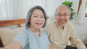 Close up of Asian elderly couple, old woman and senior man use mobile phone for video call with son, daughter and talking to grandchildren at home. Grandparent feel happy with communicate via internet