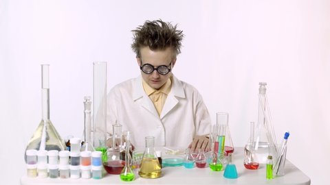 funny scientist among flasks with multi-colored liquid. a person works with chemical reagents. the laboratory assistant discovered an interesting yellow reagent. specialist prepares for work