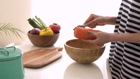 Female hands peeling vegetables on the table