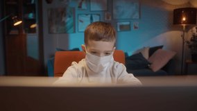 Students return to school after COVID 19 Coronavirus lockdown, kid wearing a mask doing homework on video conference call, asks questions, social distancing in the classroom. Remote home video lesson