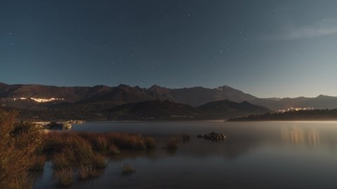 Time-lapse of stars passing over the mountains of San Parteo and Monte Grosso as dawn breaks at Lac de Codole in the Balagne region of Corsica at sunset
