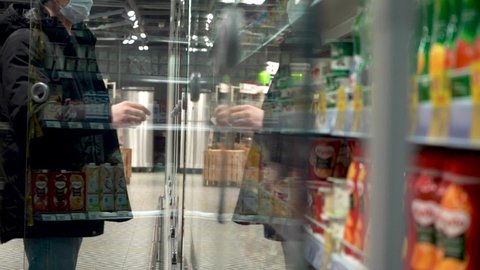Slow motion. Close-up. Dolly Shot. Male Hand Opening Glass Refrigerator Door In Supermarket. The Camera Penetrates the Refrigerator