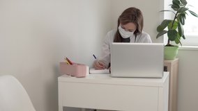 A female doctor works at a computer in her office.