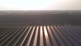 Aerial drone view into large solar panels at a solar farm at early spring sunset. Solar cell power plants. footage video 4k.