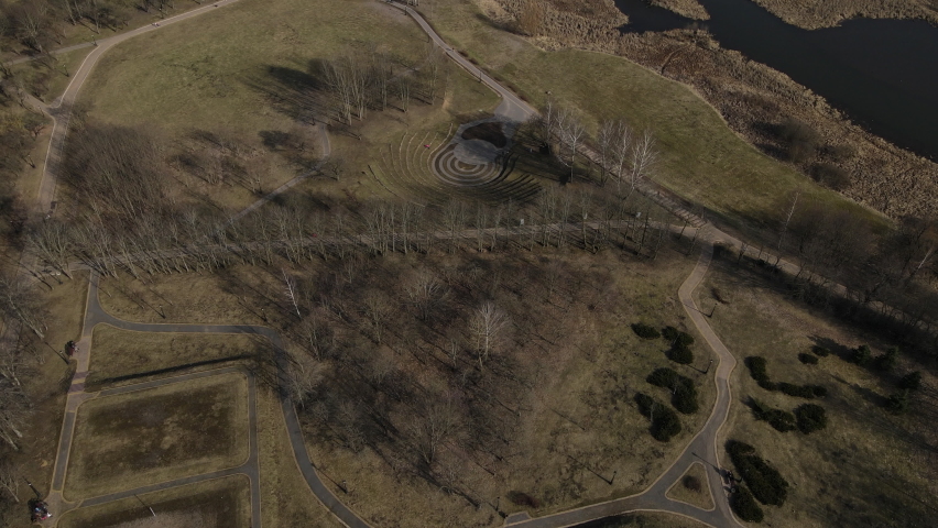 Spring in Loshitsa Park. Flight over the city park. An amphitheater made of stones is visible below