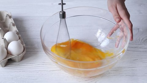 Whipping chicken eggs with a hand mixer for cooking