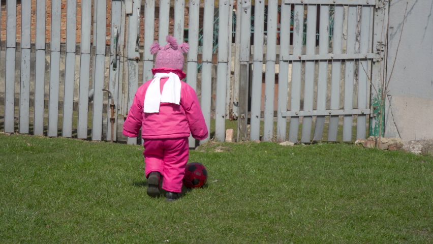 little girl playing ball,baby in the spring playing ball in the yard