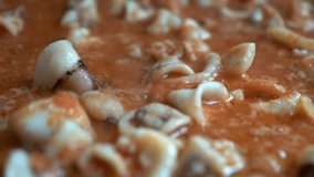 squid relying on tomato during the preparation of fideua