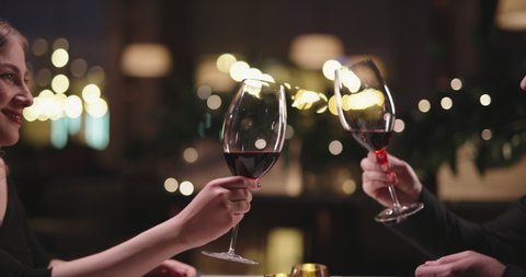 Joyful couple having a romantic dinner at a fancy restaurant. People enjoying their date, drinking wine, eating and chatting 4k footage