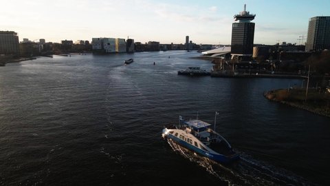 Amsterdam, 25th of March 2021, The Netherlands. GVB public transport ferry crossing the Ij river aerial. Following the ferry near central station.