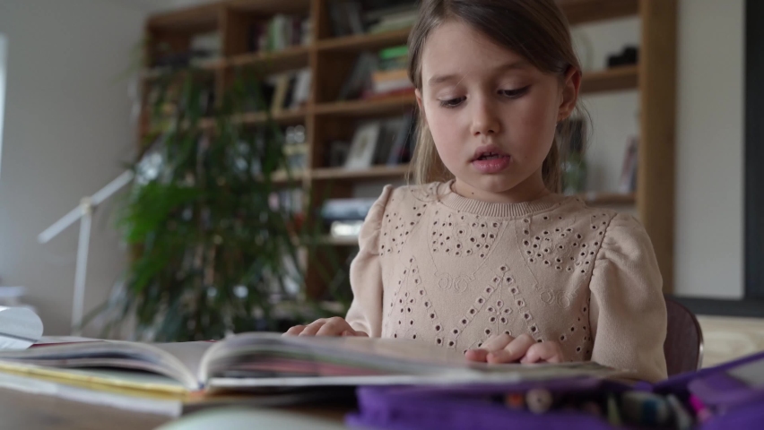 Little girl reading out loud from exercise book