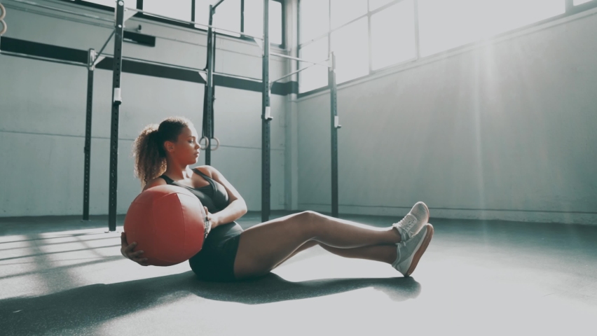 Young woman doing core training with gym ball