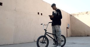 Young afro man rapper making a selfie with his trials bike in the street.Young millennial urban lifestyle