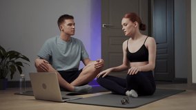 A girl and her boyfriend are watching meditation lessons on a laptop and trying to relax