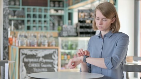Woman using Smartwatch in Caf�