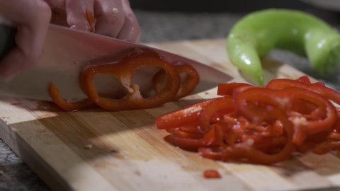 Chopping Red Capia Pepper with Knife on Cutting Board in Kitchen. Close Up, Real Time 4K UHD.  