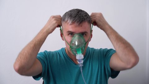Male puts on an oxygen mask and self isolates from COVID-19 Pandemic.