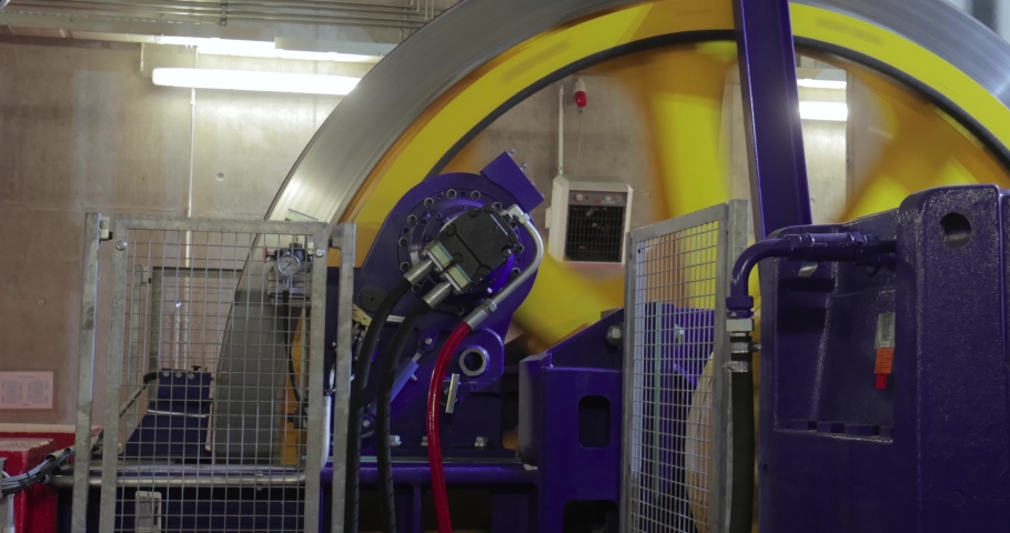 Big flywheel spinning in the industrial engine room of a cabin ski lift