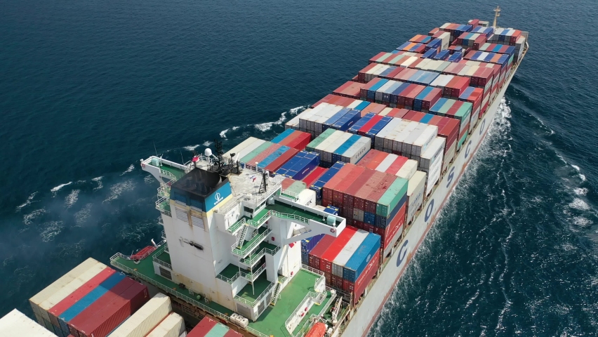 Piraeus, Attica - Greece - June 21 2020: Aerial drone video of fully loaded COSCO container tanker ship cruising near port of Piraeus