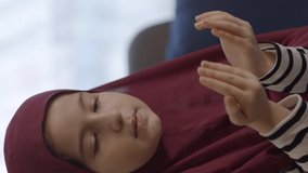 Muslim little girl wearing hijab, praying to god.Muslim little girl prays to god.Video for the vertical story.
