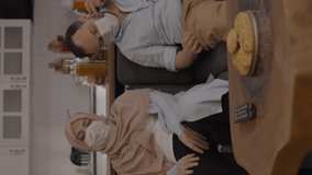 The young woman in hijab and the young man with a beard, who comes home tired from outside, leave themselves on the sofa and take off their masks.Video for the vertical story.