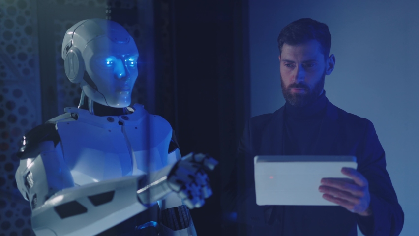 In ofice businessman work talking with cybernetic robot use transparent screen. Futuristic employees. Robot and human collaboration. Communication, project, development. Slow motion