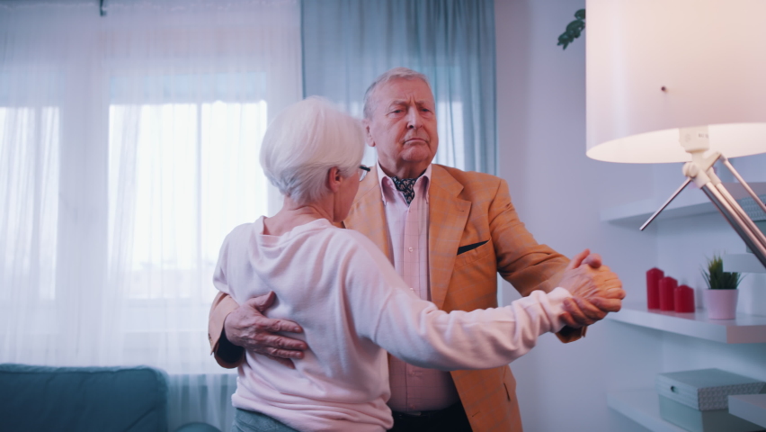 Happy old married couple dancing in hotel room. Valentines day or anniversary celebration. High quality 4k footage