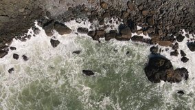 Aerial drone video of a rocky coastline shore with waves 