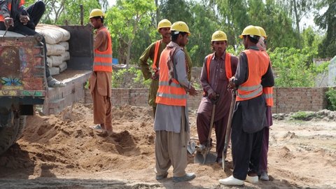 KOT ADU - MARCH 25, 2021: A Worker Name Karim Is Doing A Job On The Road Making With His Friends In Pakistan 4k Clip