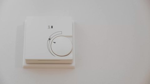Adjusting a Thermostat to Warm Up the Room