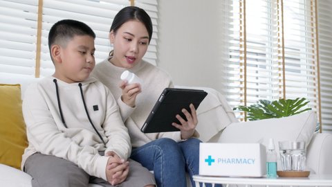Young asia parents and son talk to doctor on cellphone videocall conference medical app in pediatric care online telehealth telemedicine online service hospital quarantine social distance at home.