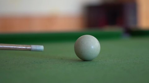 Closeup slow motion shot of cue shooting snooker ball on the snooker table.