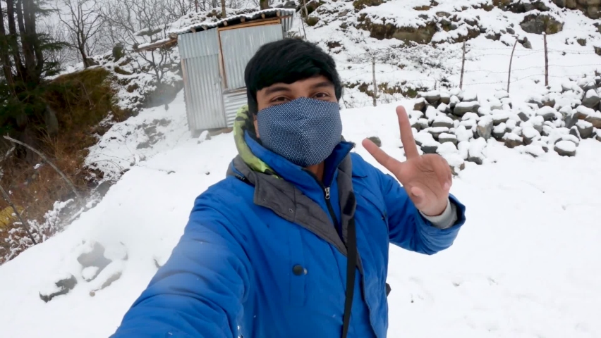 Selfie video of an Indian man wearing mask enjoying the snowfall while following the new Covid Travel Guidelines at Manali in Himachal Pradesh, India | Shutterstock HD Video #1070066887