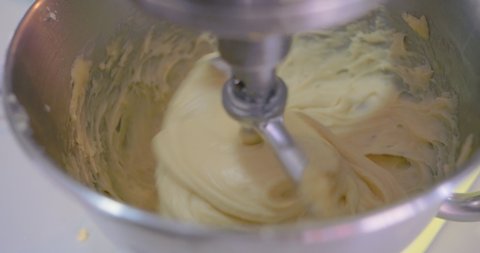 Raw dough in a bakery dough mixer. Bread making process by using flour mixing machine. Preparation of dough on home kitchen. Kneading the dough. The process of making a delicious treat or dessert.