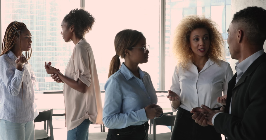 Diverse African businesspeople communicating during break in modern office boardroom, brainstorming together, share ideas work on project, discuss current business. Teamwork, workflow process concept. Royalty-Free Stock Footage #1070073601