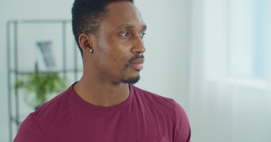 Young african man standing at home and smiling. Portrait nice looking attractive african american man posing with happy smile. Concept of people and emotions.