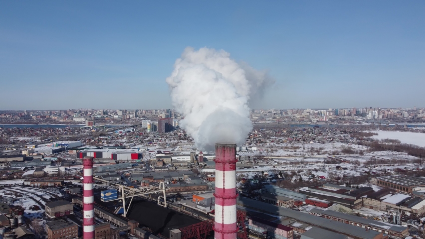 white smoke coming from a huge chimney of the thermal power plant flies towards the big city of Novosibirsk