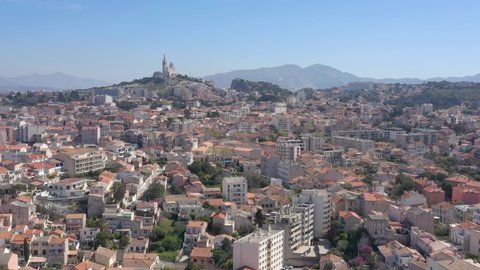 France, 7th arrondissement of Marseille. Drone aerial view flying above buildings roofs with Notre-Dame de la Garde Basilica in back. Former city of Bernard Tapie.