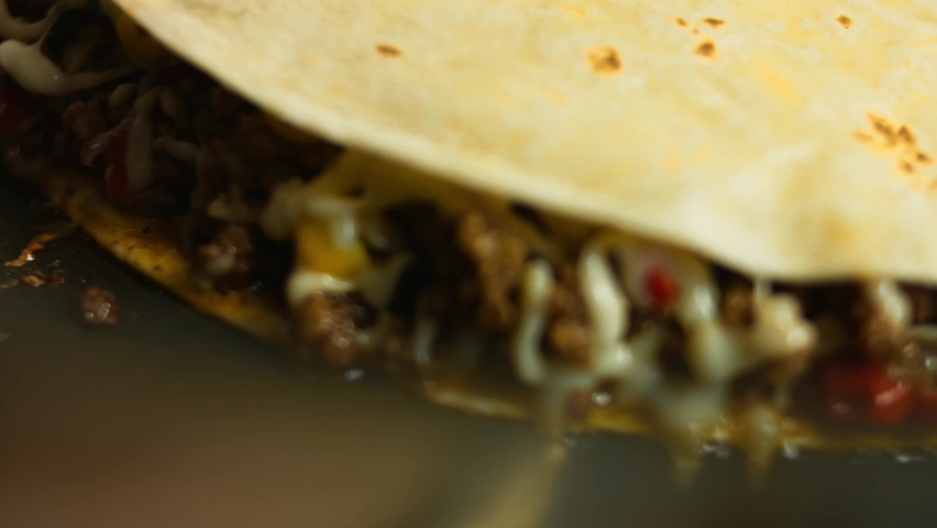 Frying a freshly wraped beef quesadilla on a frying pan. Process of making mexican quesadillas. Macro view Royalty-Free Stock Footage #1070089948